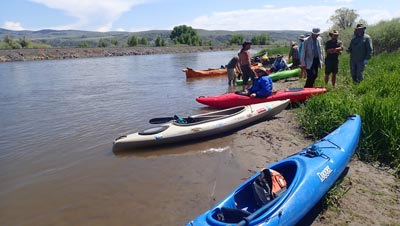 Kayaks and canoes on a river beach..